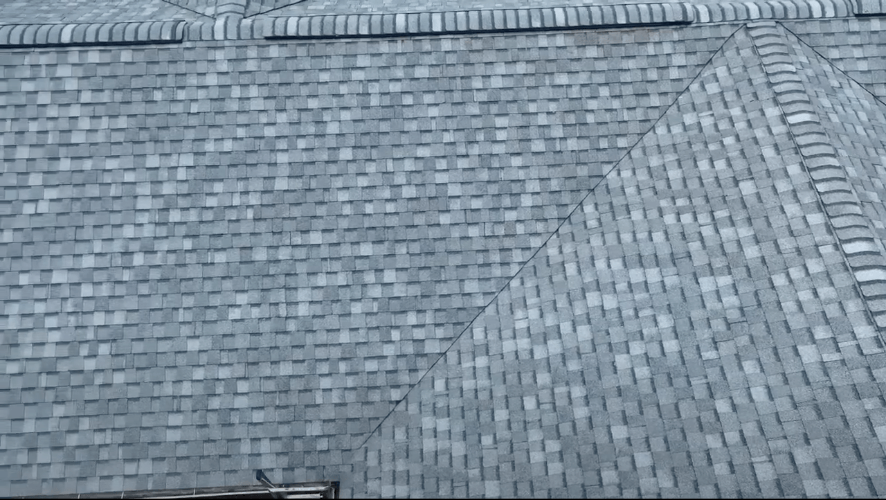 A close up of a gray roof with a triangle shaped roof.