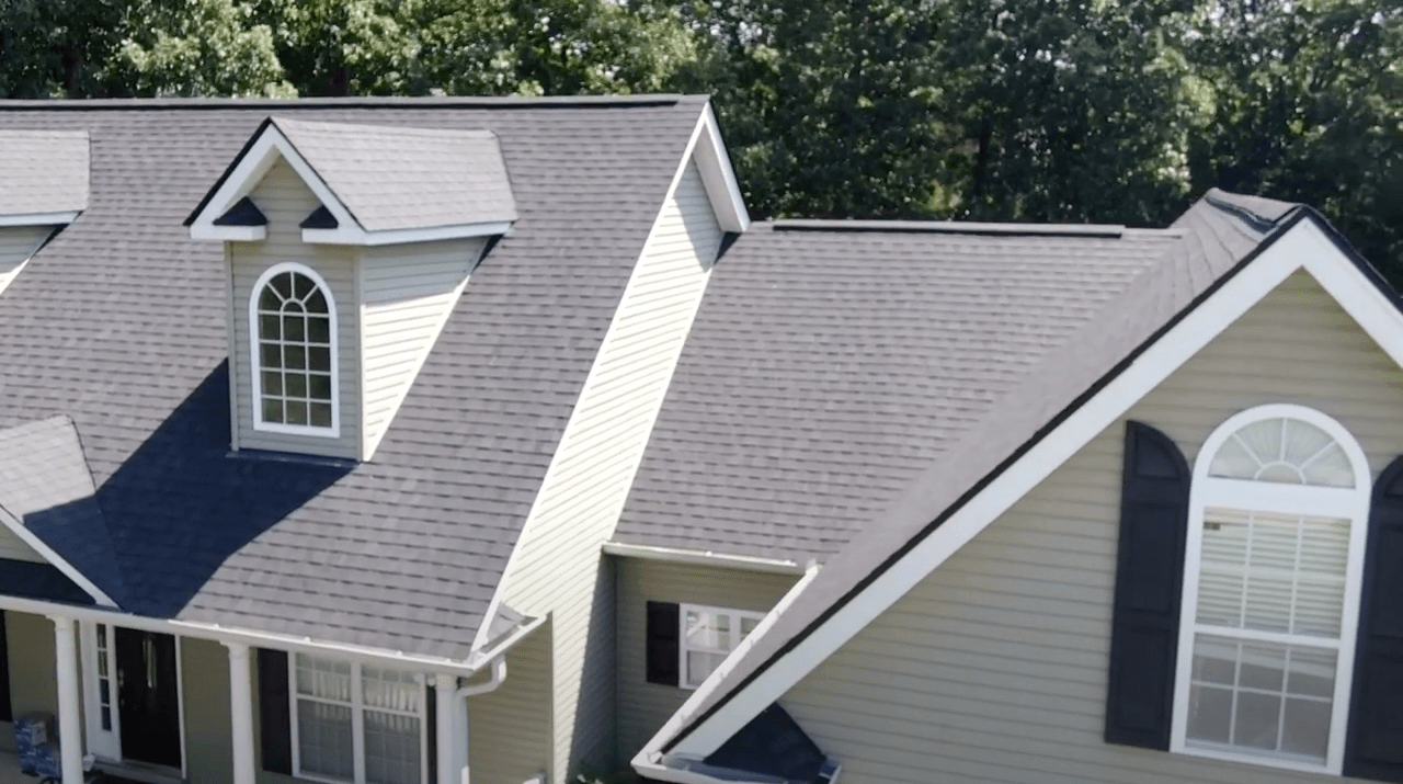 An aerial view of a house with a gray roof