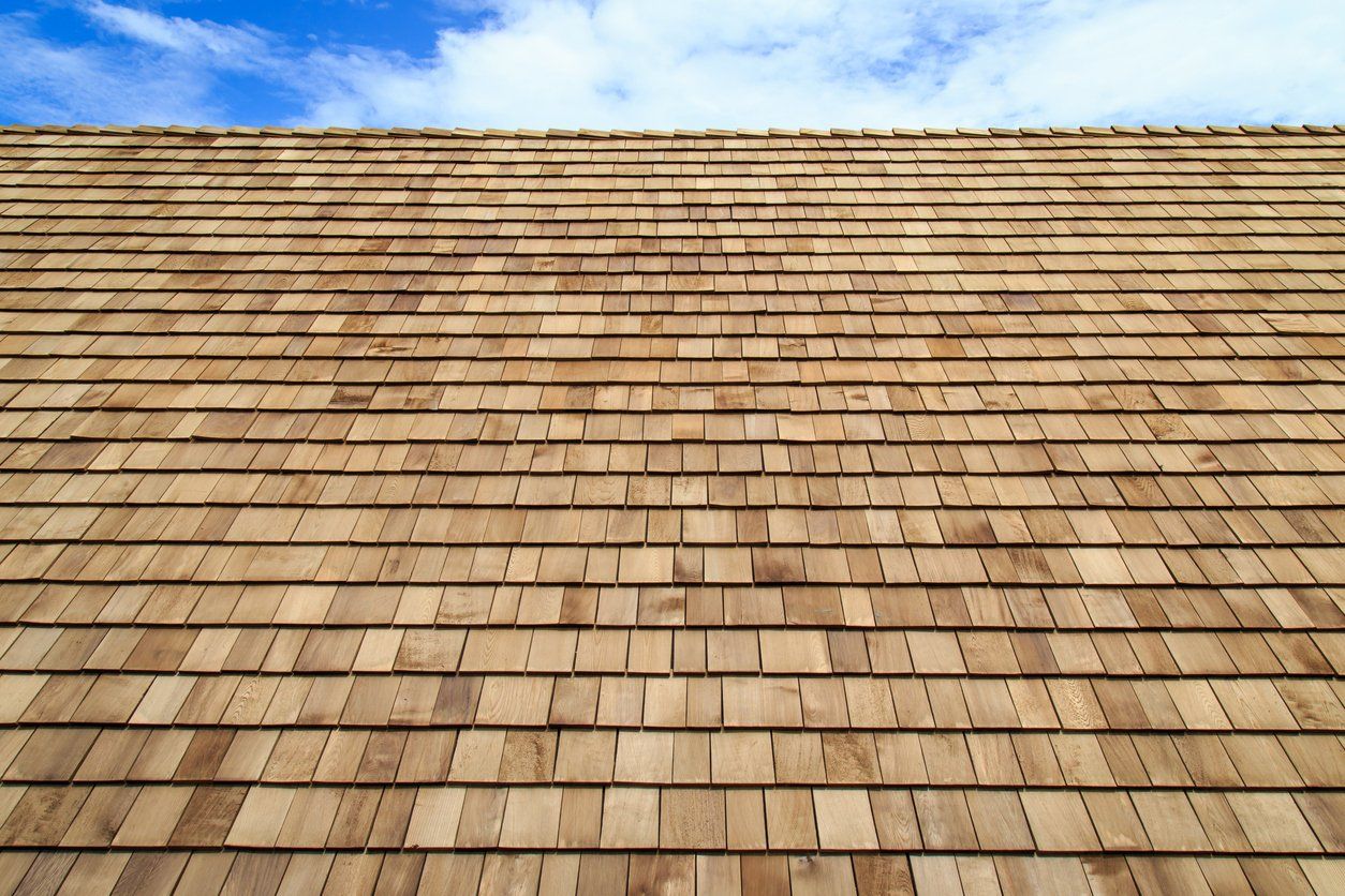 Looking up at a wooden roof with a blue sky in the background