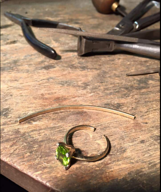 a ring with green stone being repaired
