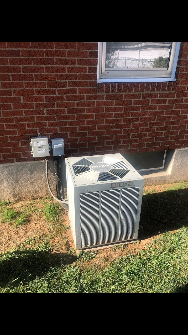 Air conditioning unit outside a brick building.