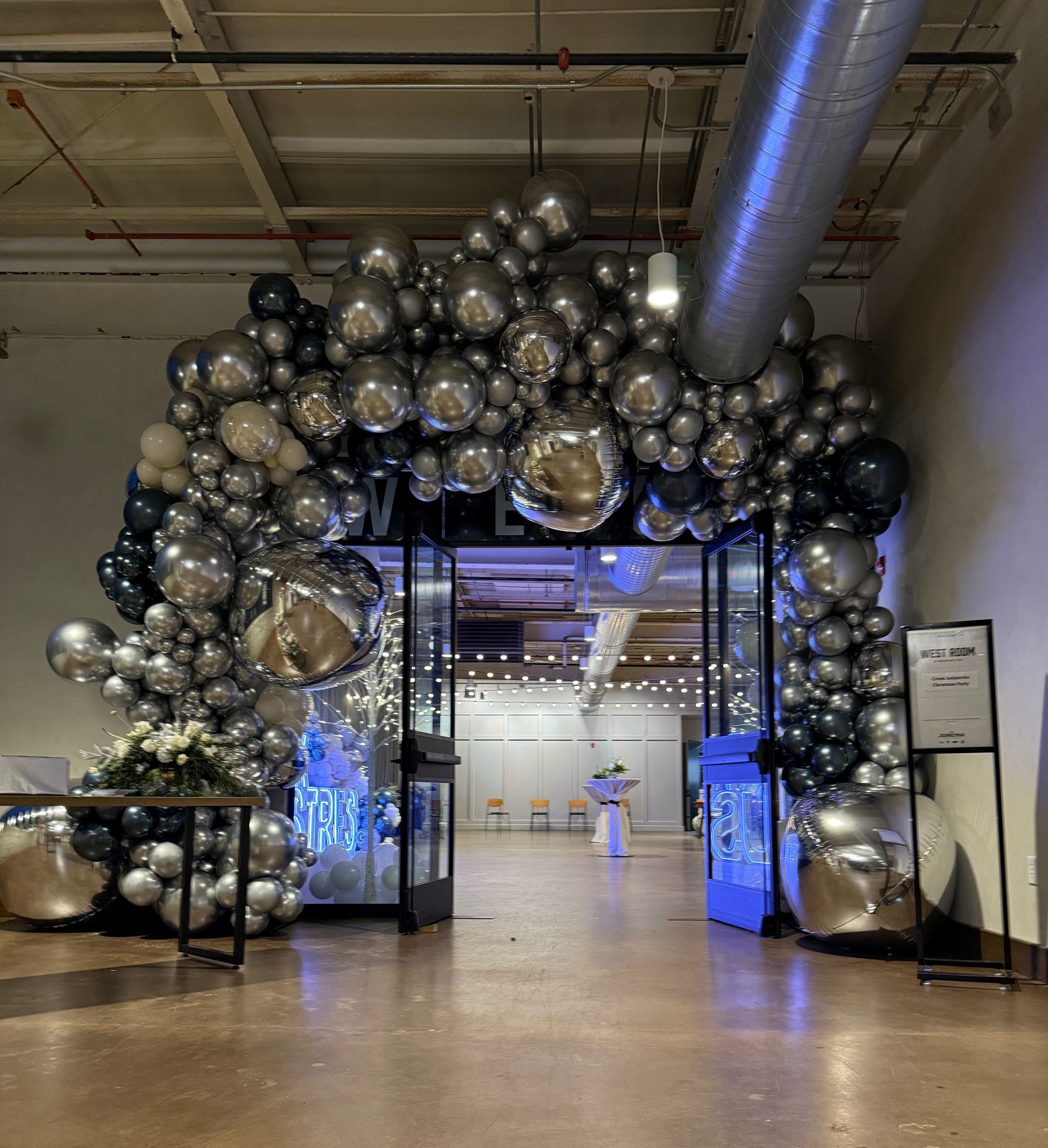 Gold, black, and white balloon decor on step and repeat for crossroads chamber gala