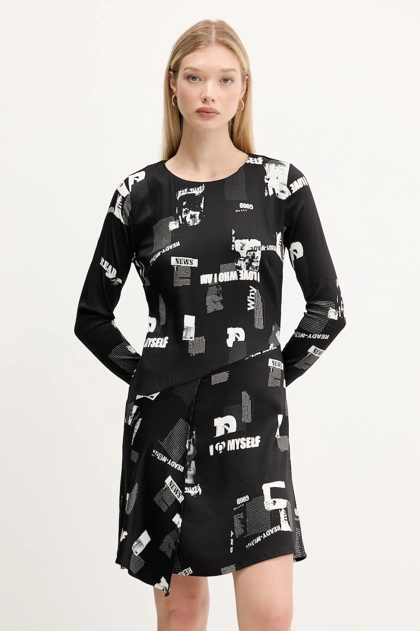 Donna con un abito a fantasia bianca e nera, in posa davanti a uno sfondo bianco.