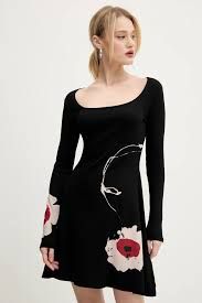 Donna che indossa un abito nero con stampa floreale e maniche lunghe.