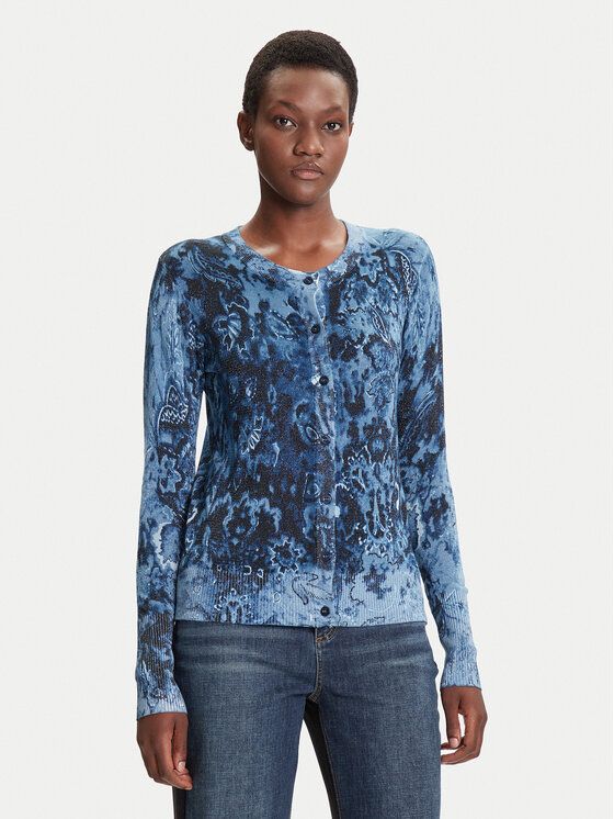 Donna che indossa un cardigan con fantasia blu e nera e jeans.