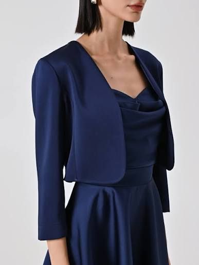 Donna con giacca bolero e abito blu navy.