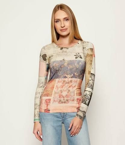 Donna che indossa una maglietta a maniche lunghe con stampa e jeans azzurri.