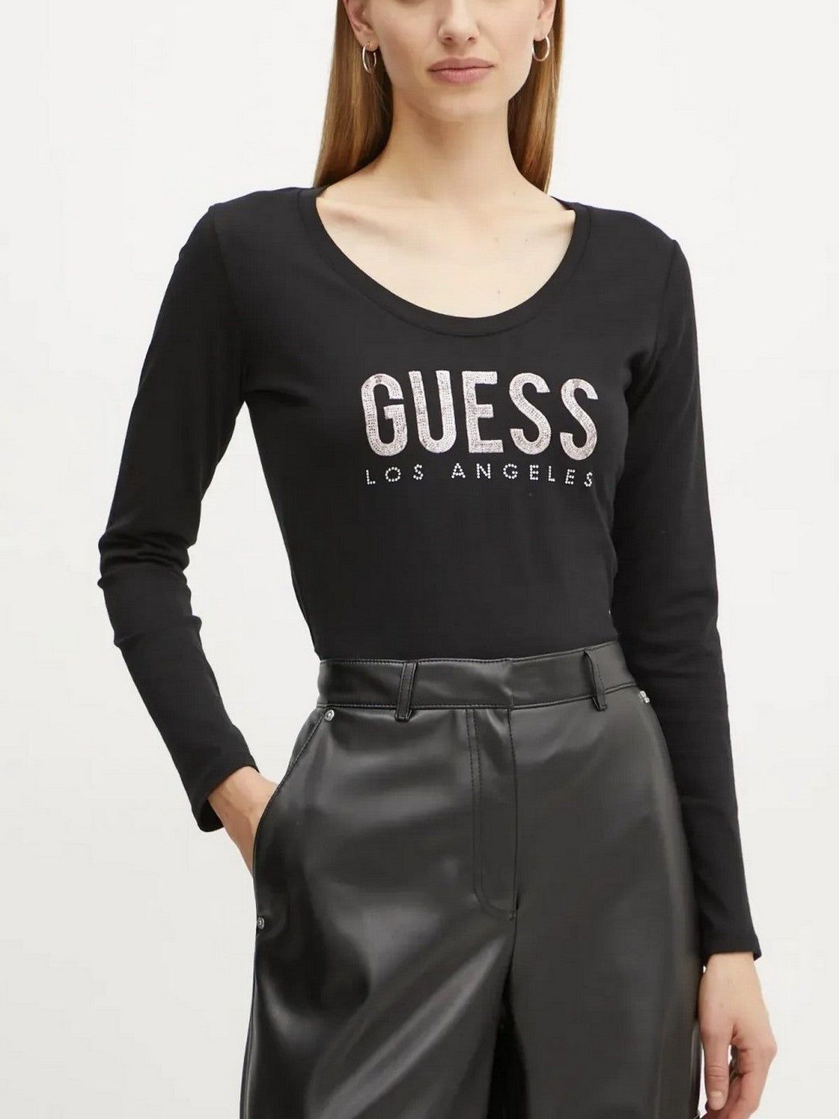 Donna in piedi con camicia nera a maniche lunghe con logo 