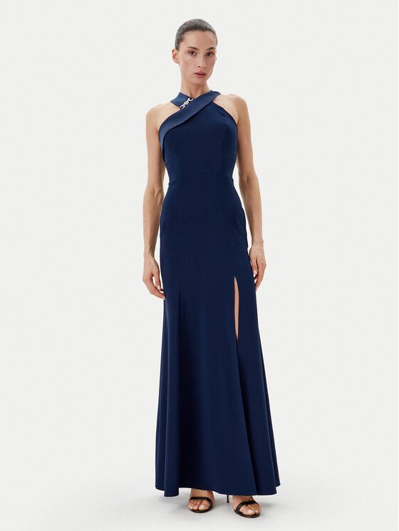 Donna in abito blu navy con scollo all'americana e spacco fino alla coscia, in posa in studio.