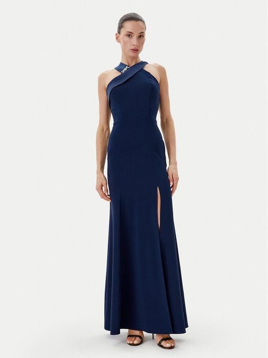 Donna in abito blu navy con scollo all'americana e spacco fino alla coscia, in posa in studio.