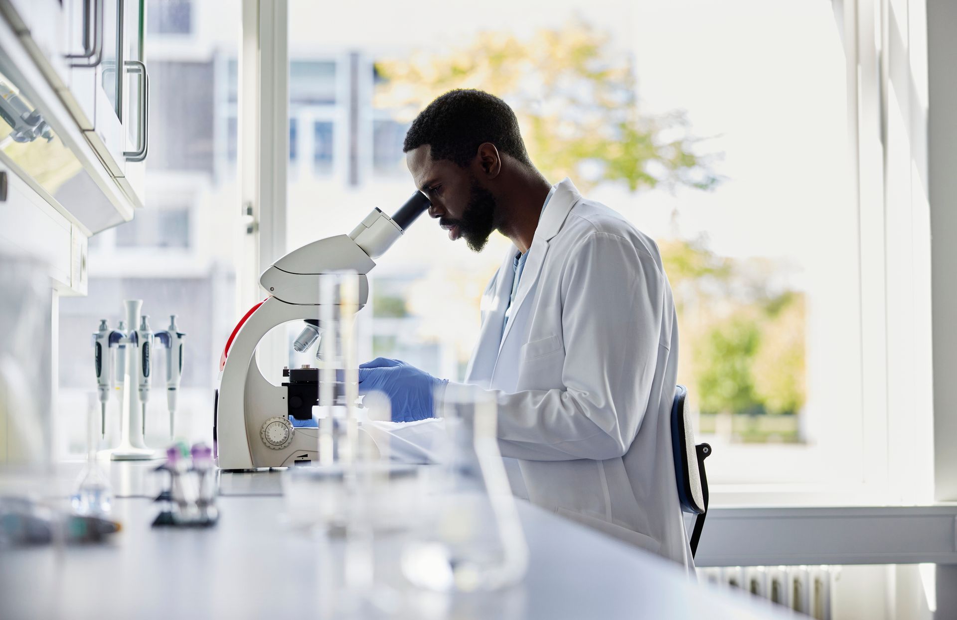 A scientist is looking through a microscope in a laboratory.