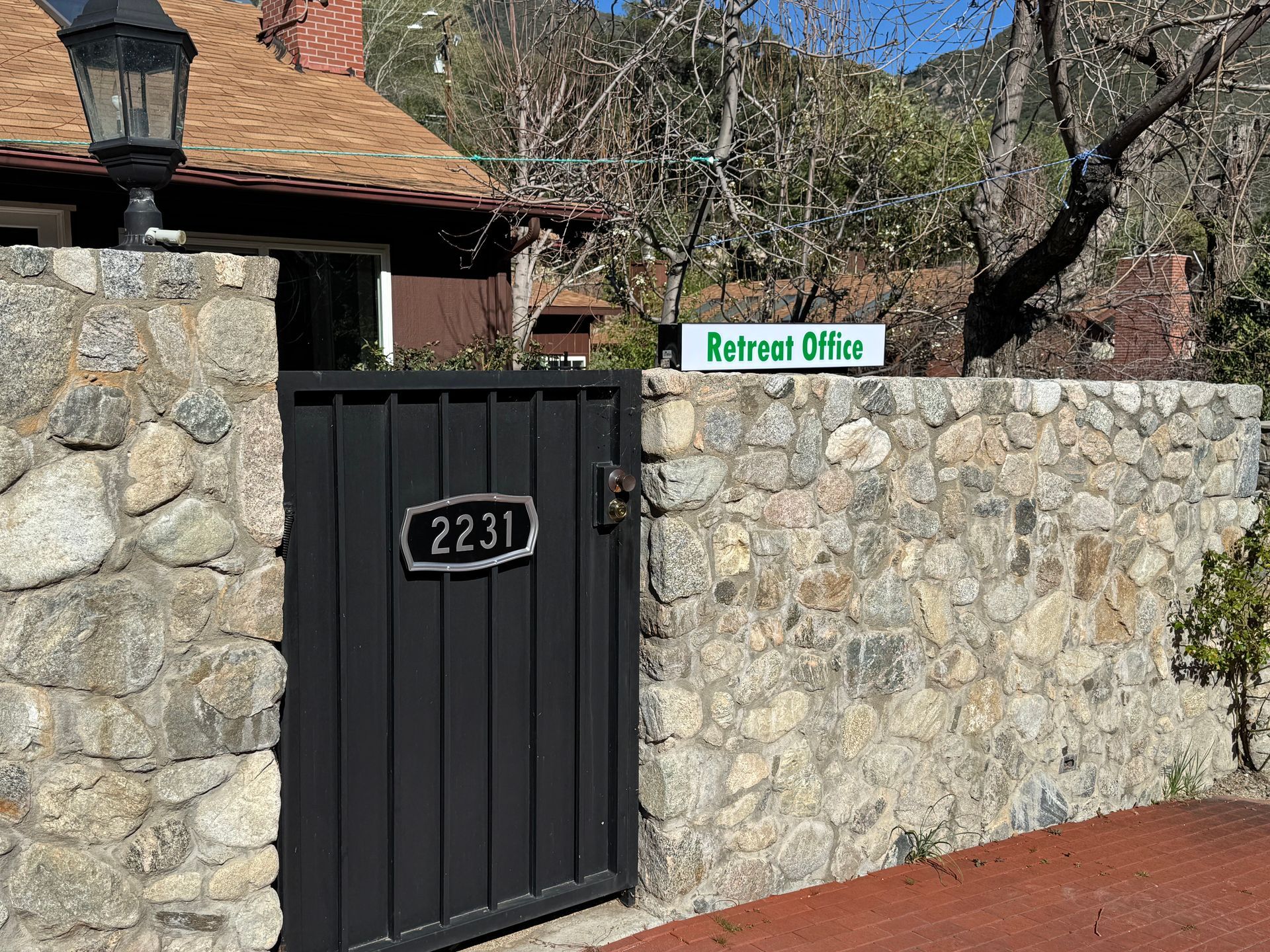 A stone wall and black gate marked 