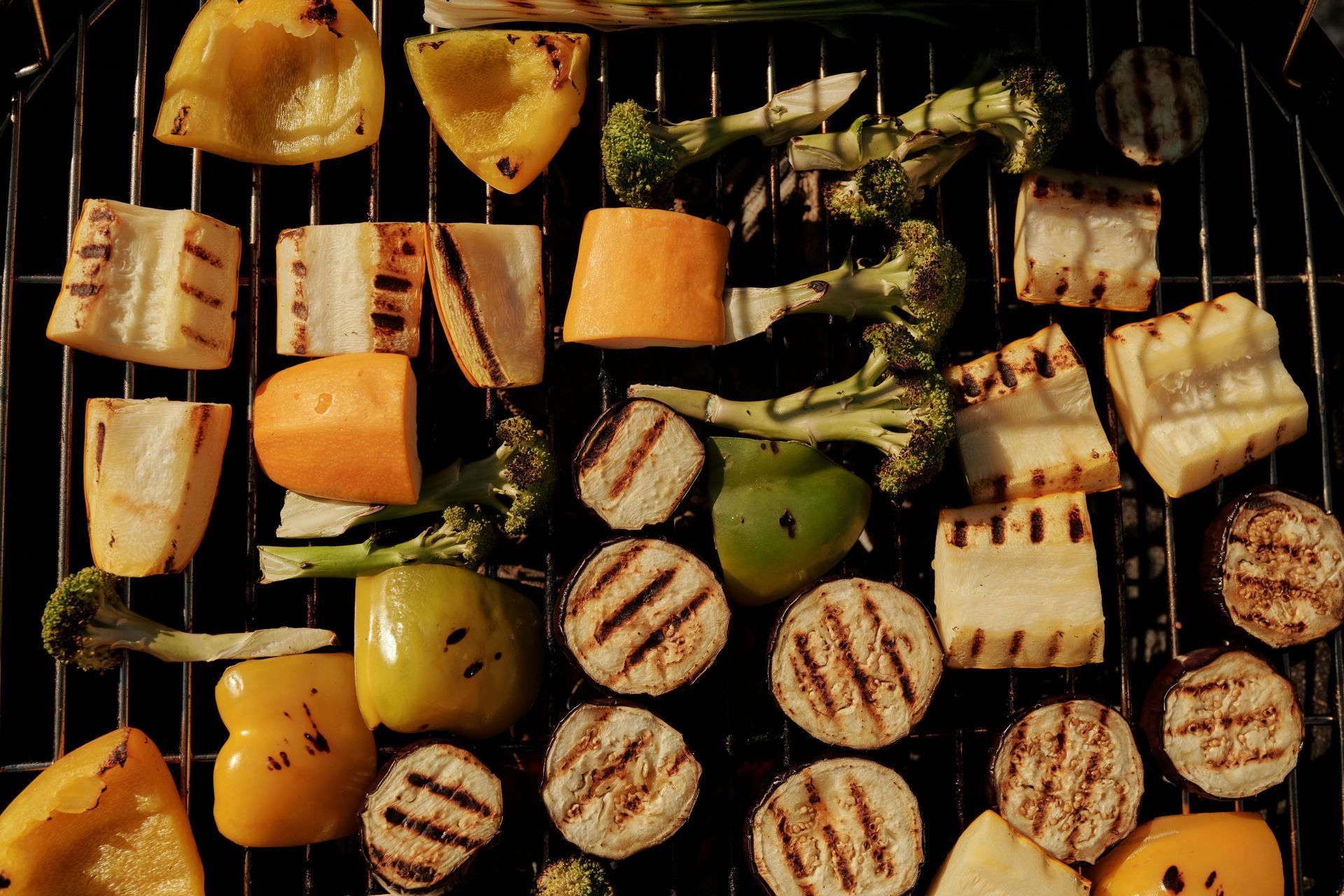 Grilled colorful vegetables on a barbecue grill.