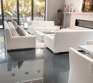 A living room with white furniture and a fireplace