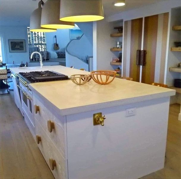 A kitchen with a large island and a stove top oven
