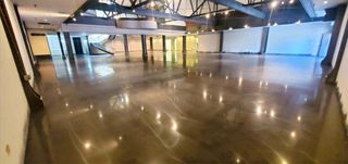 A large empty room with a shiny concrete floor.