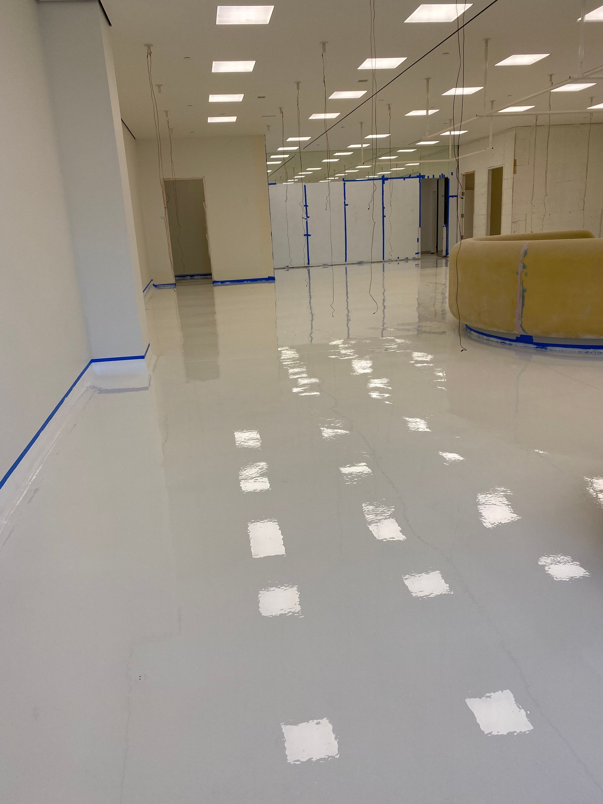 A large white room with a lot of lights on the ceiling.