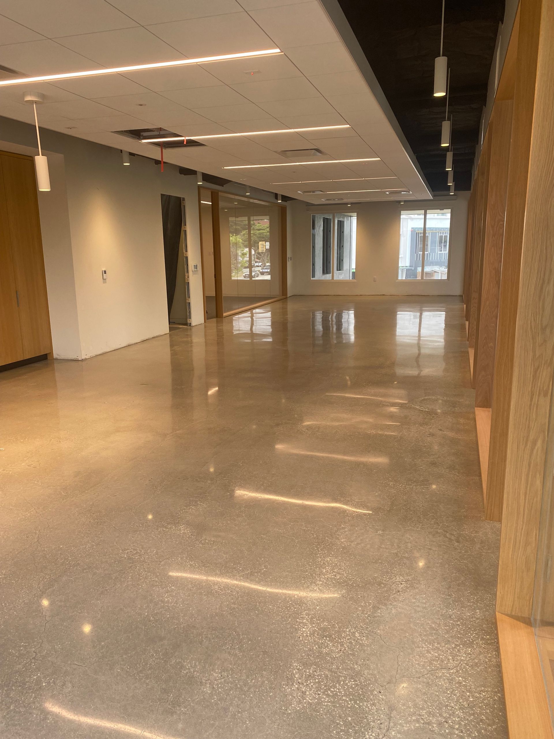 A large empty room with a shiny floor and a lot of windows