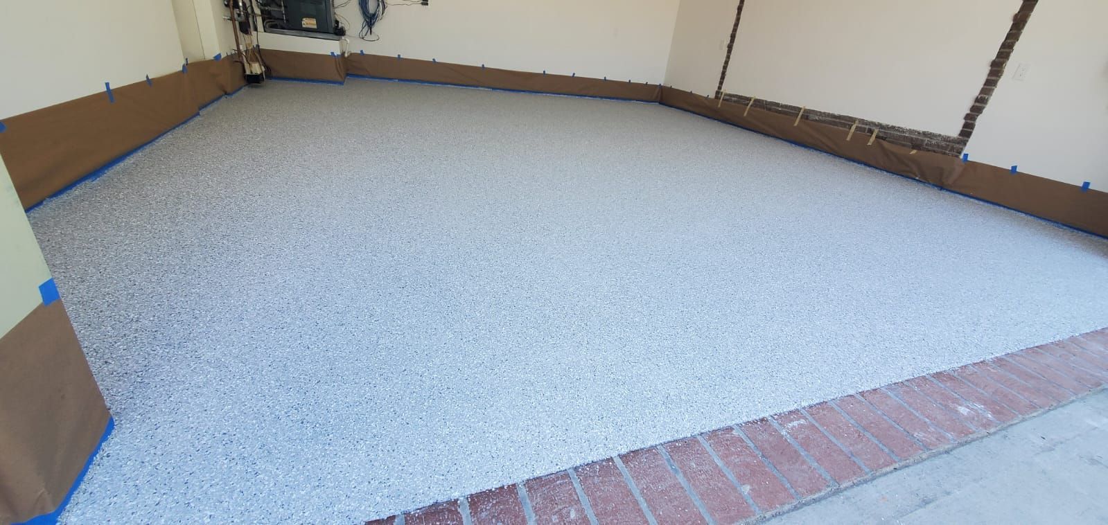 A concrete floor with a brick border in a garage.