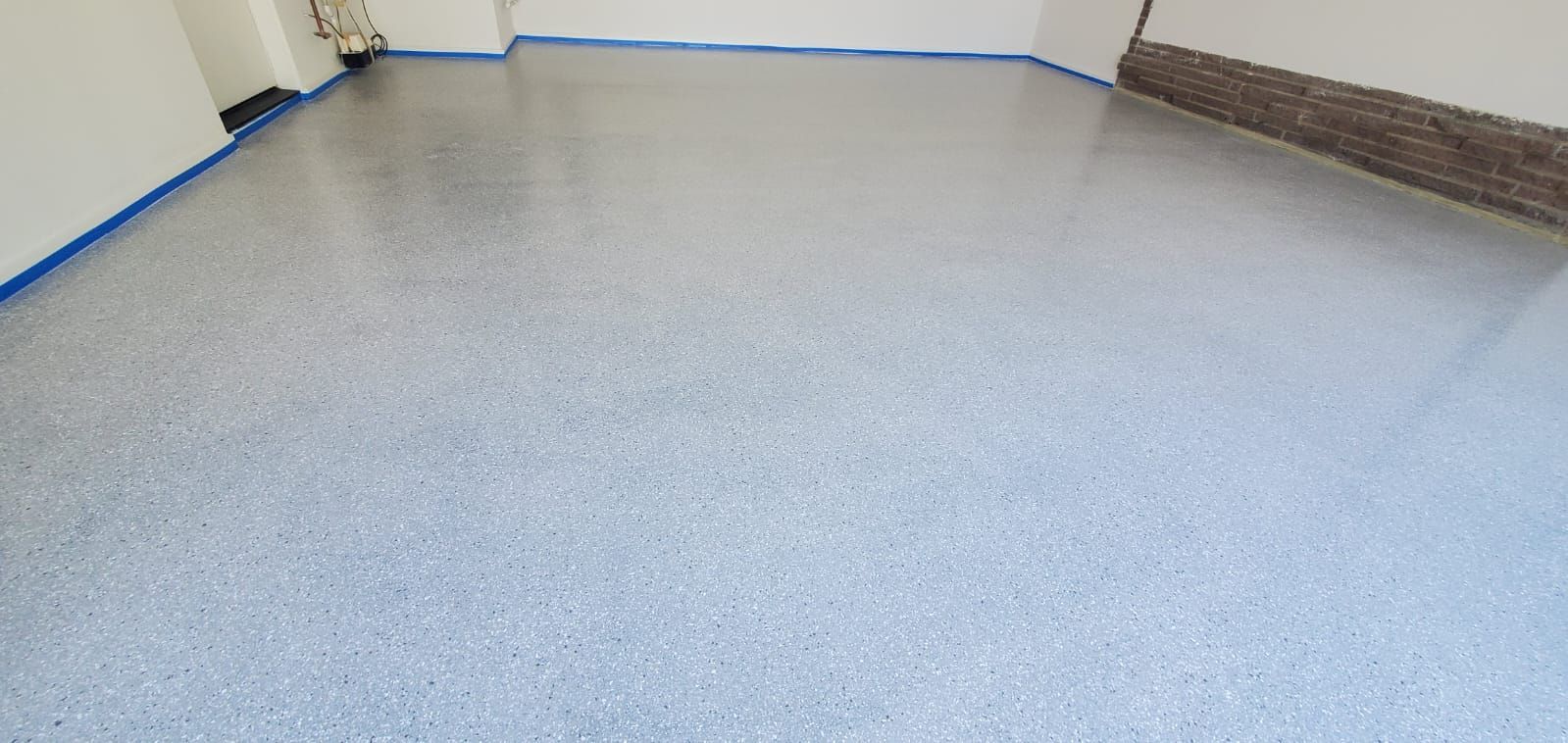 A garage with a gray concrete floor and white walls.