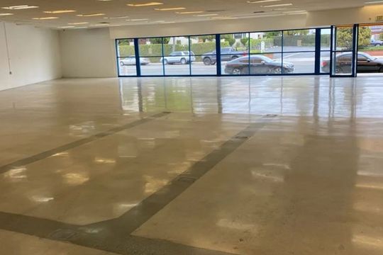 A large empty room with a lot of windows and a shiny floor.