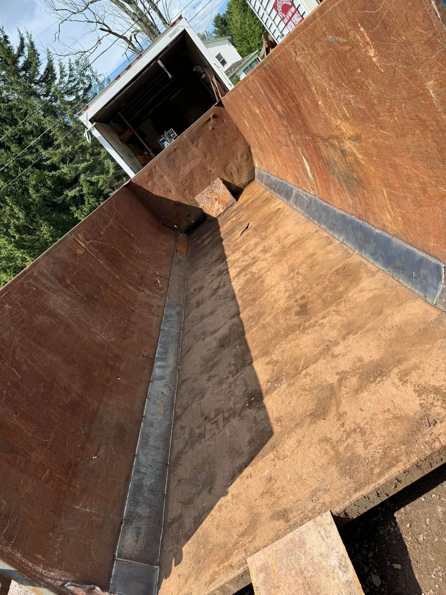 Rusty brown dumpster from an upward angled perspective.