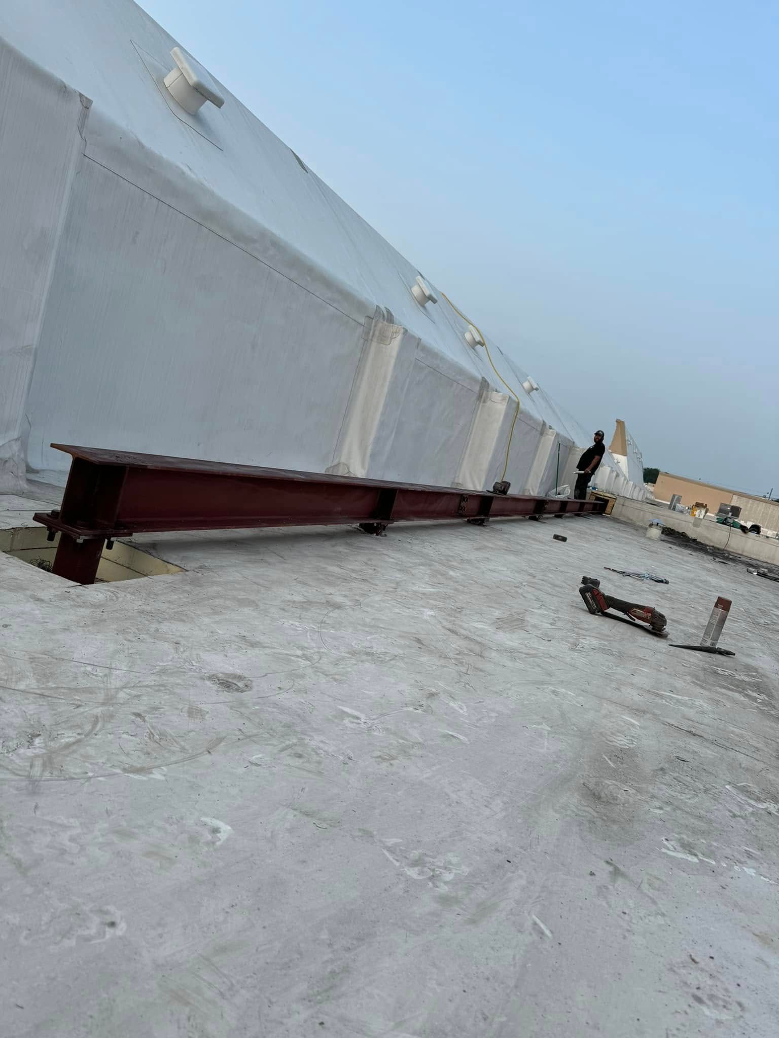 Red metal beam supports a white slanted structure on a flat gray surface.