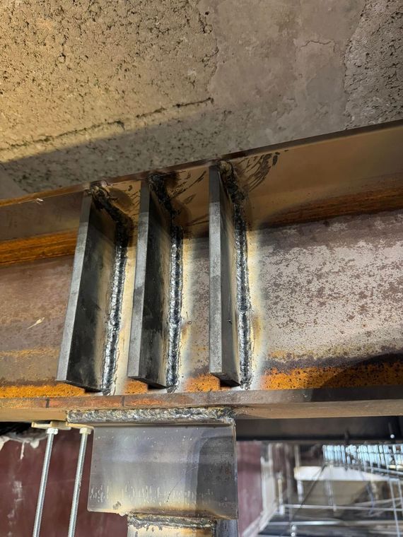Steel beams and gussets welded together, showing structural support in a building.