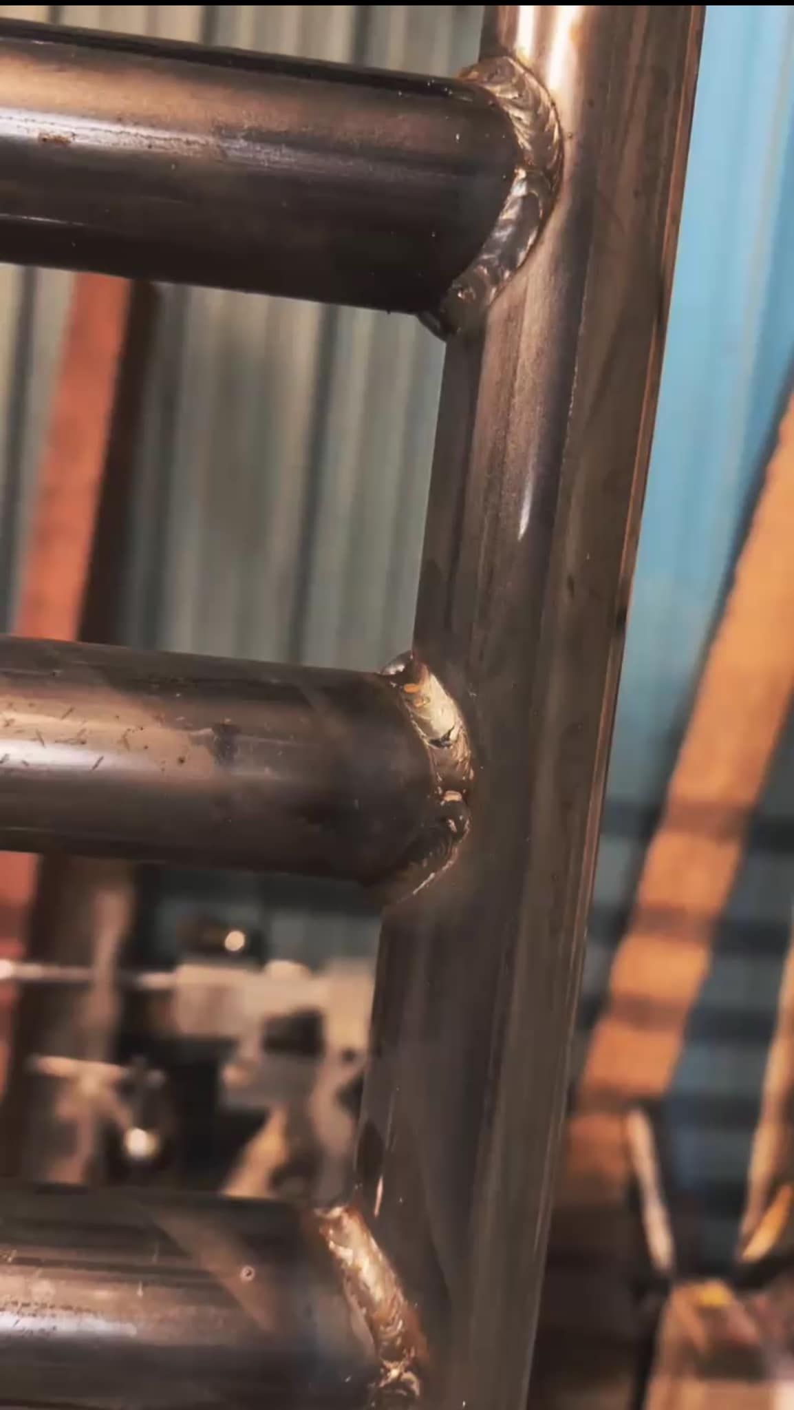 Welded metal frame with horizontal bars; industrial setting.