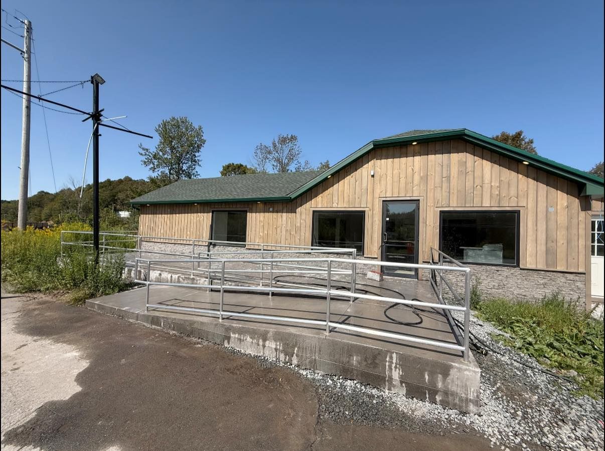 A wooden building with a wheelchair ramp under a blue sky.