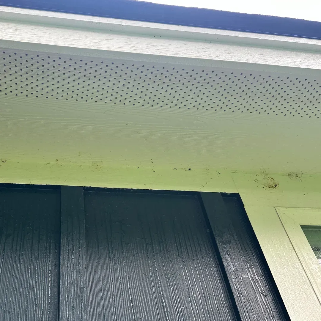 A close up of the roof of a house with a window.