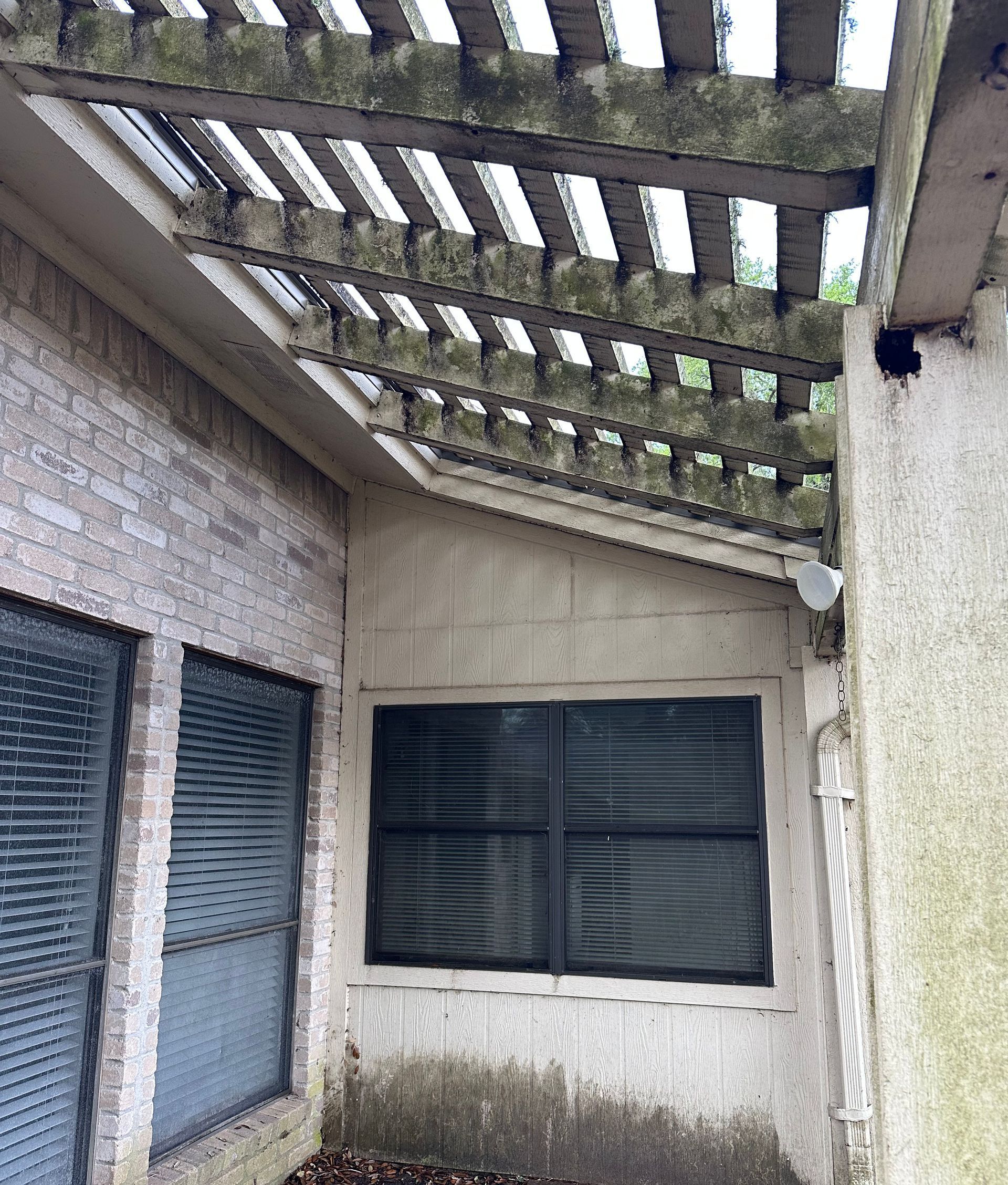 A brick building with a pergola and a window