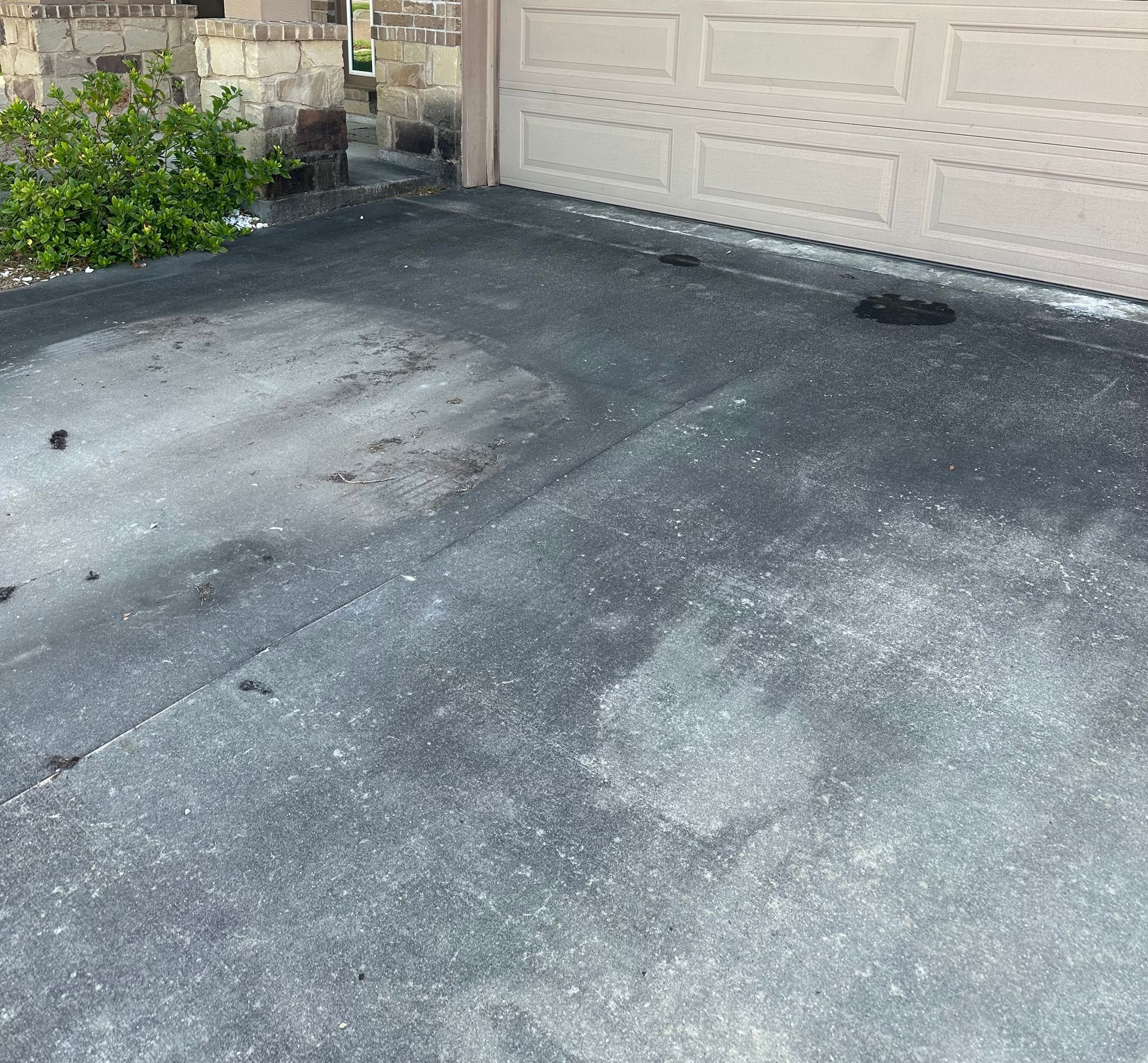 A concrete driveway with a garage door in the background