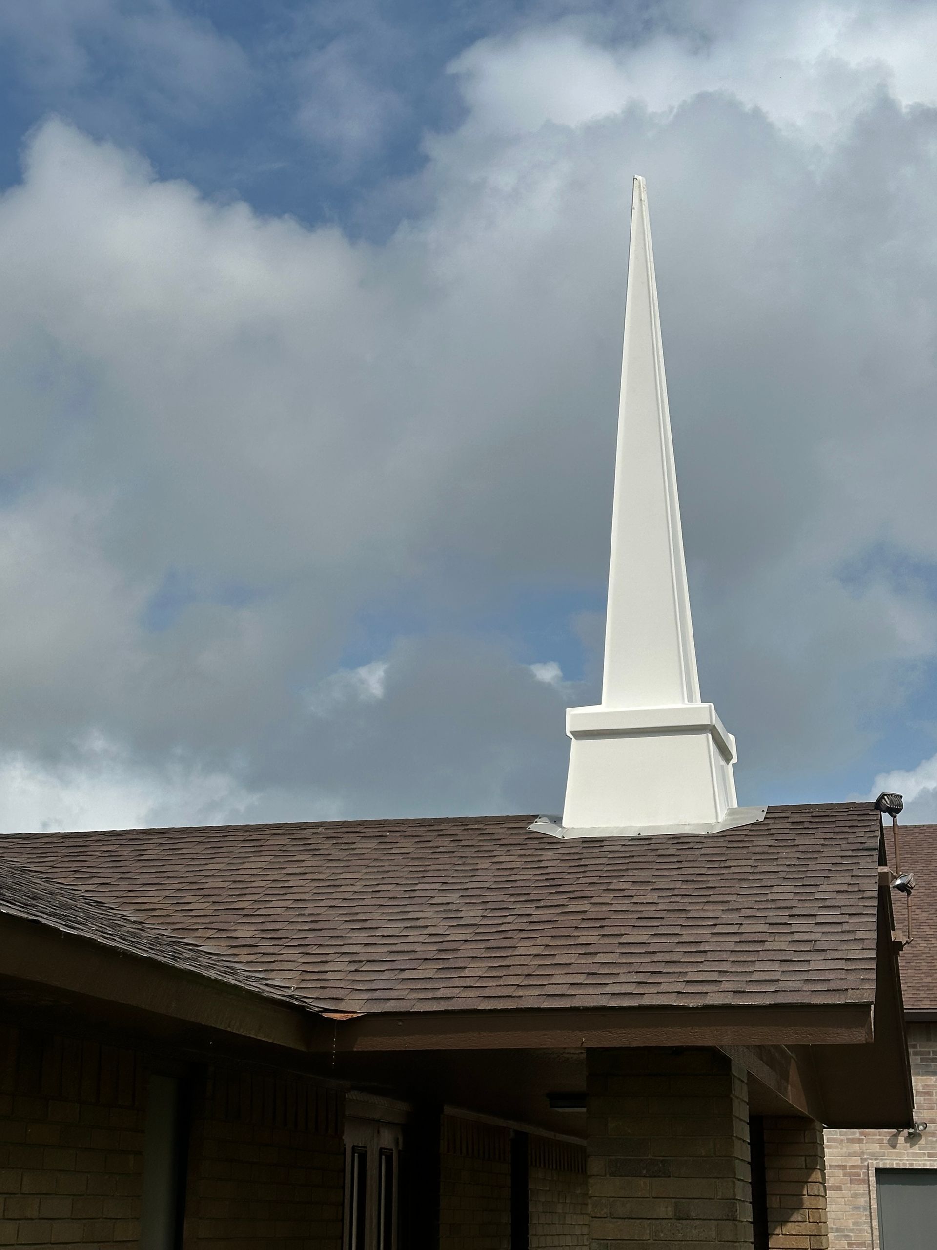 A church steeple with a cloudy sky in the background