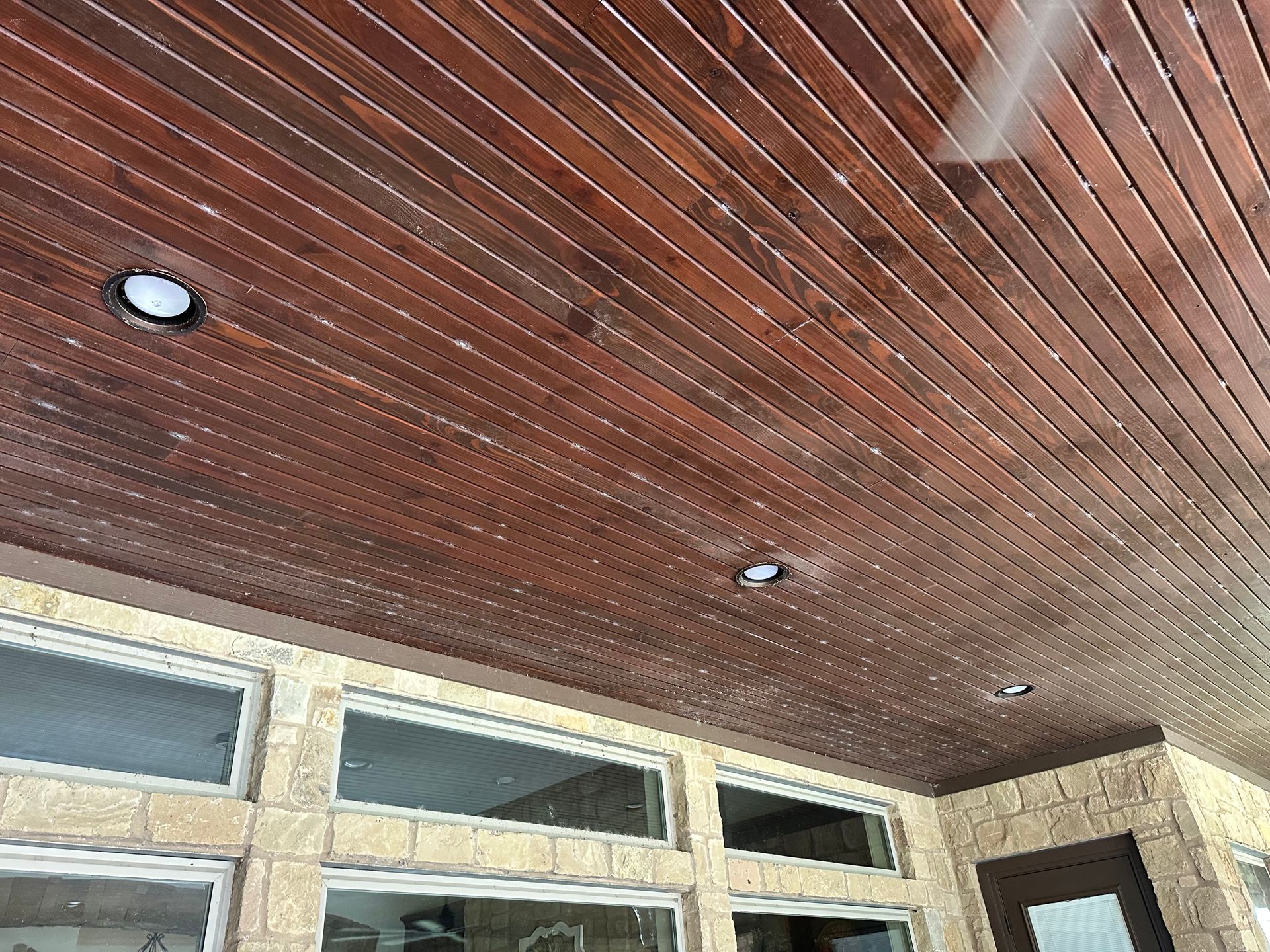 A wooden ceiling with a fan hanging from it.