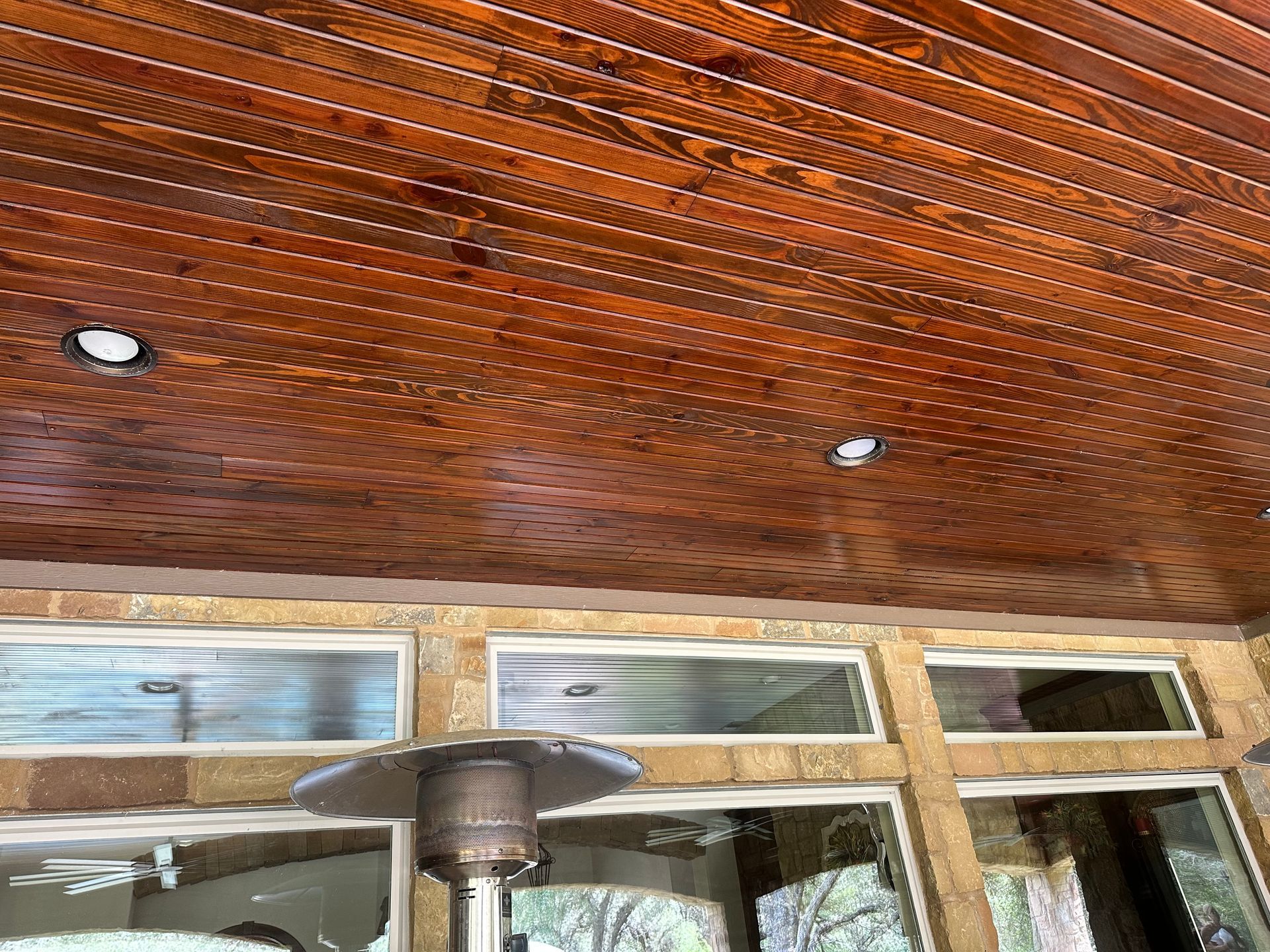 A wooden ceiling with a heater on it and a lot of windows.