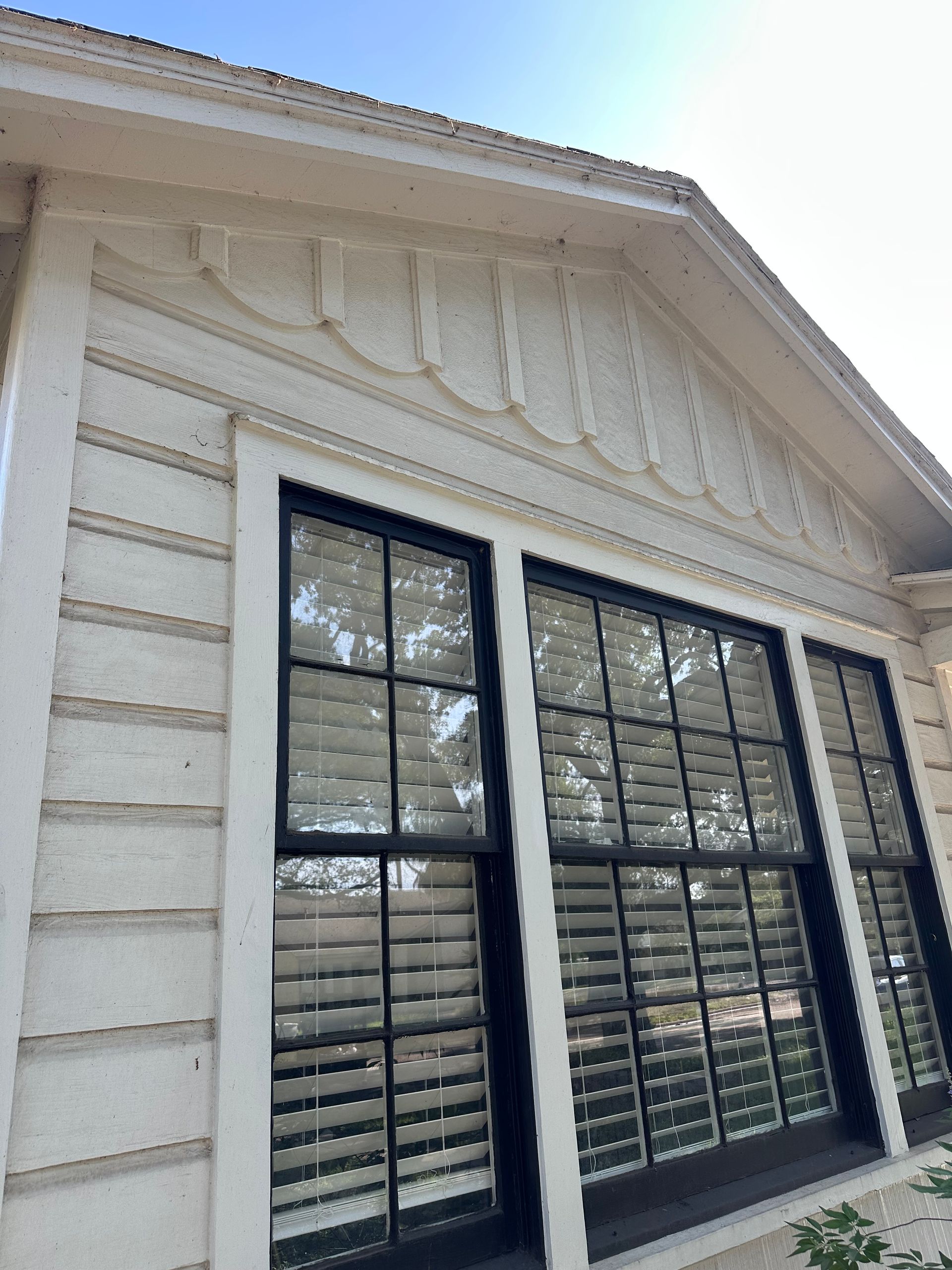 A white building with black shutters on the windows