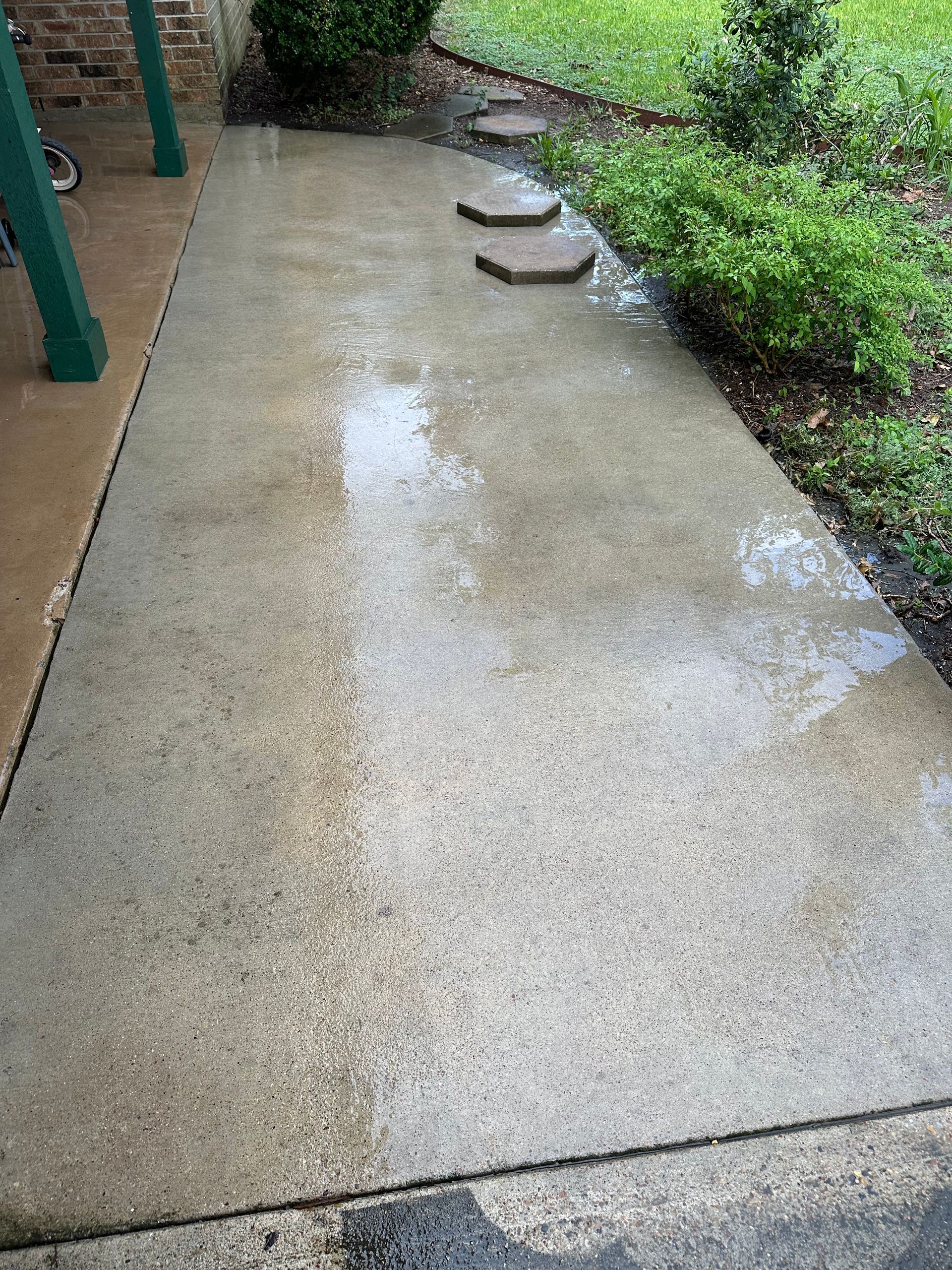 A concrete walkway with stepping stones in the middle of it.