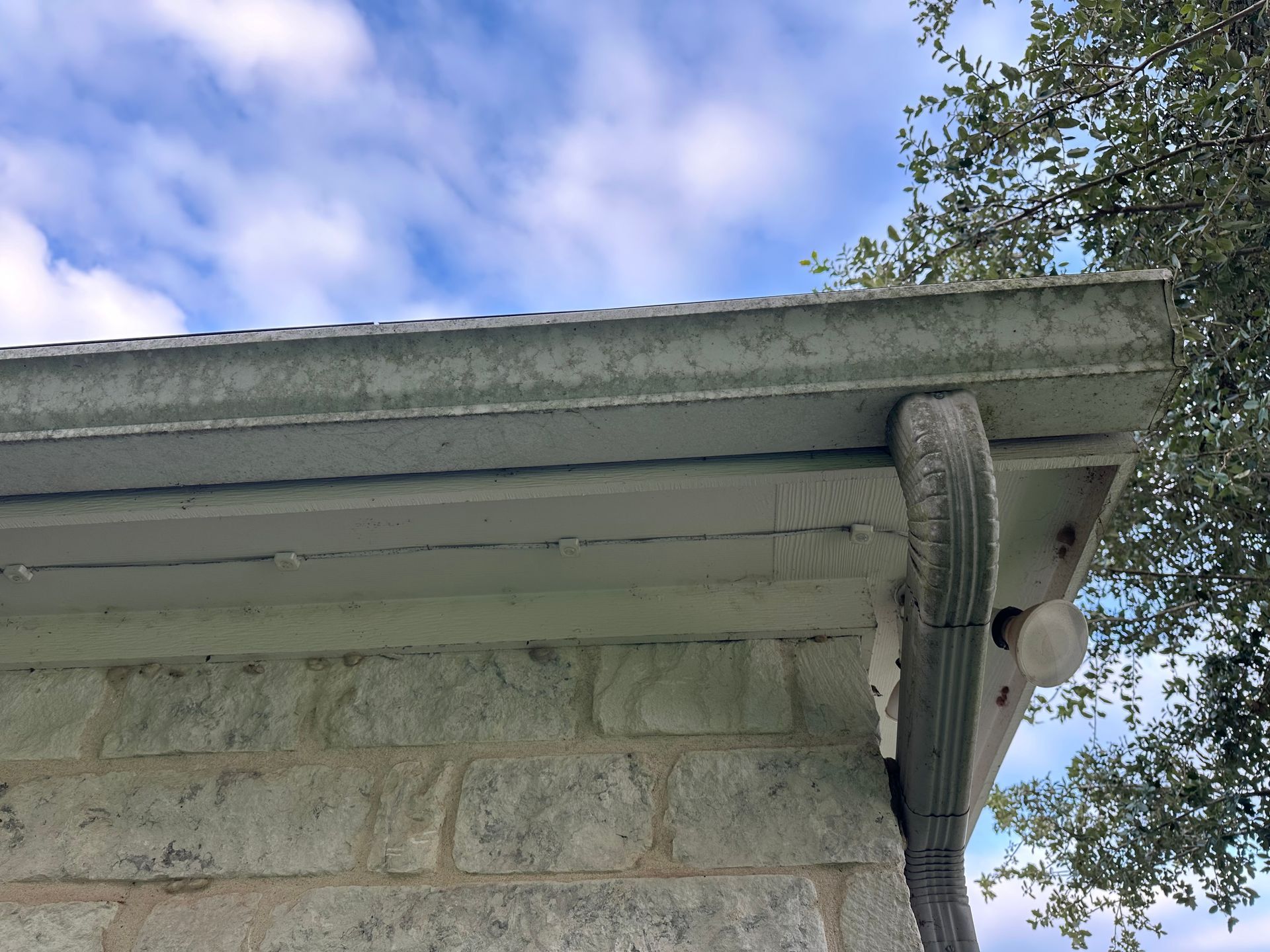 A brick building with a gutter on the side of it