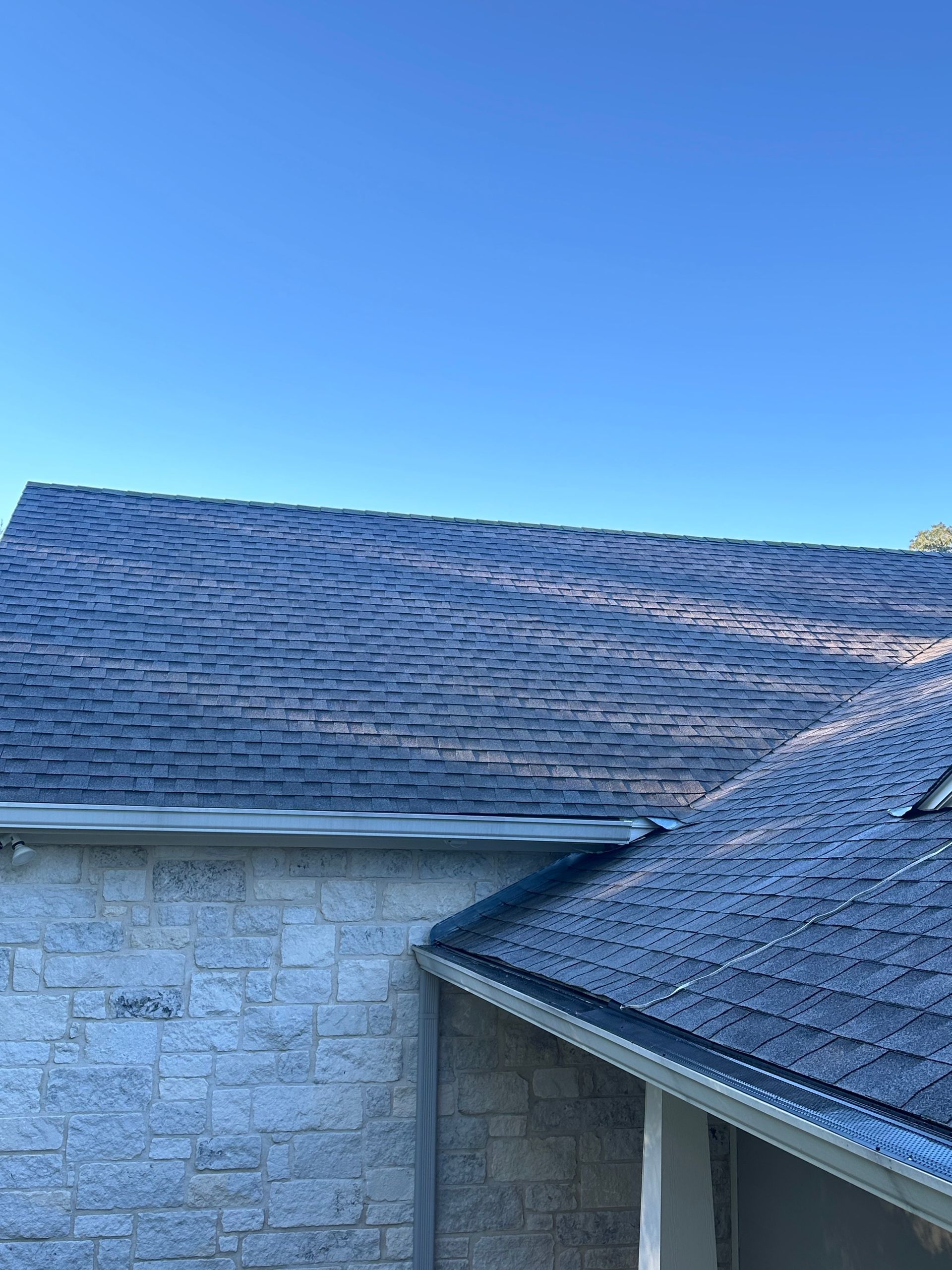 The roof of a house with a blue sky in the background.
