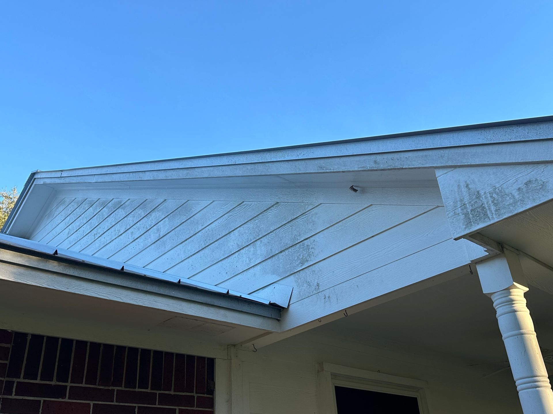 The roof of a house with a blue sky in the background.