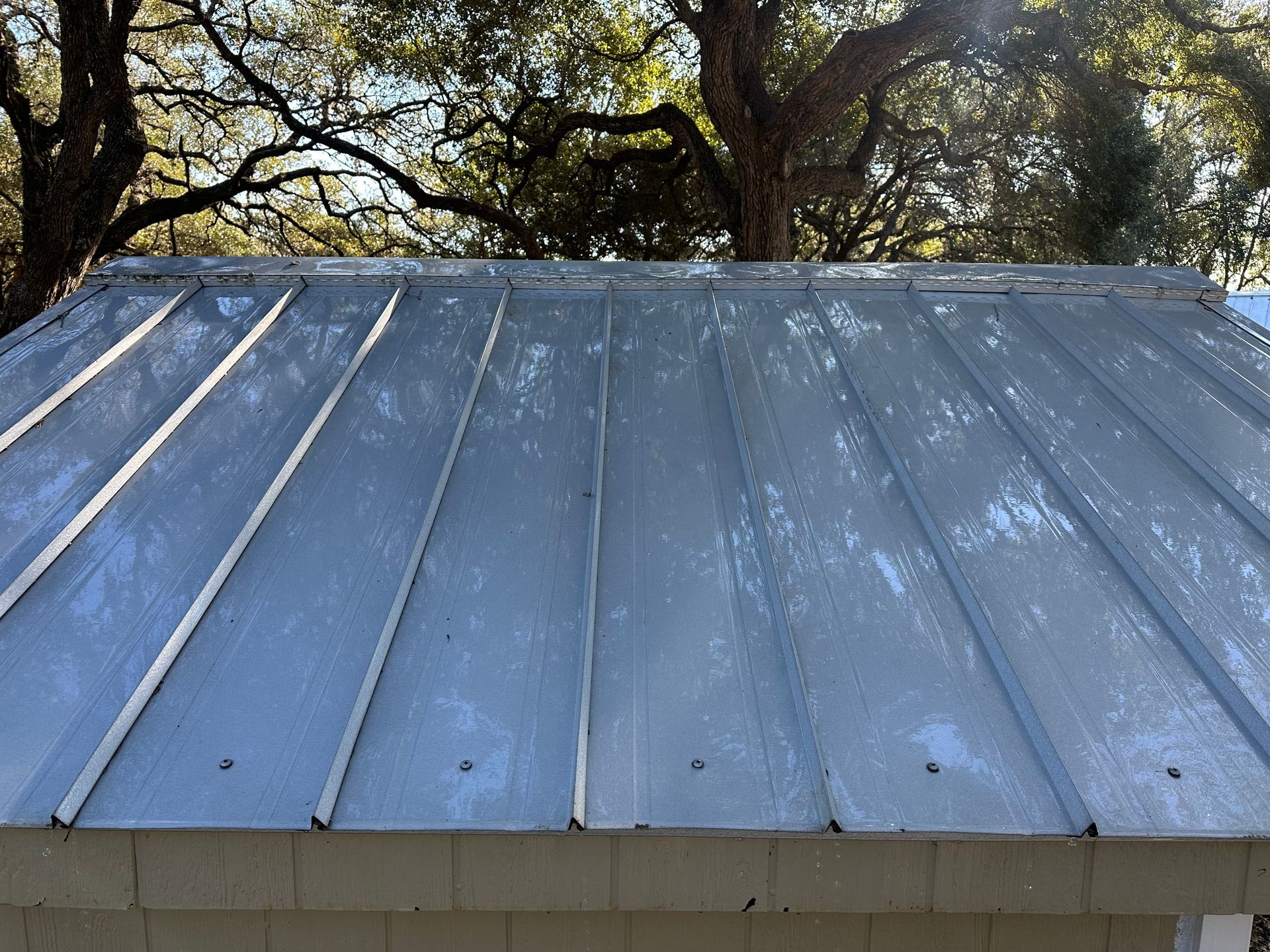 A metal roof with trees in the background