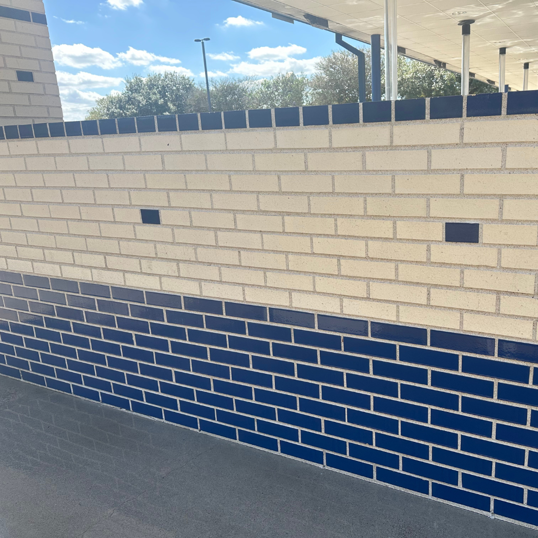 A white brick wall with blue tiles on the bottom