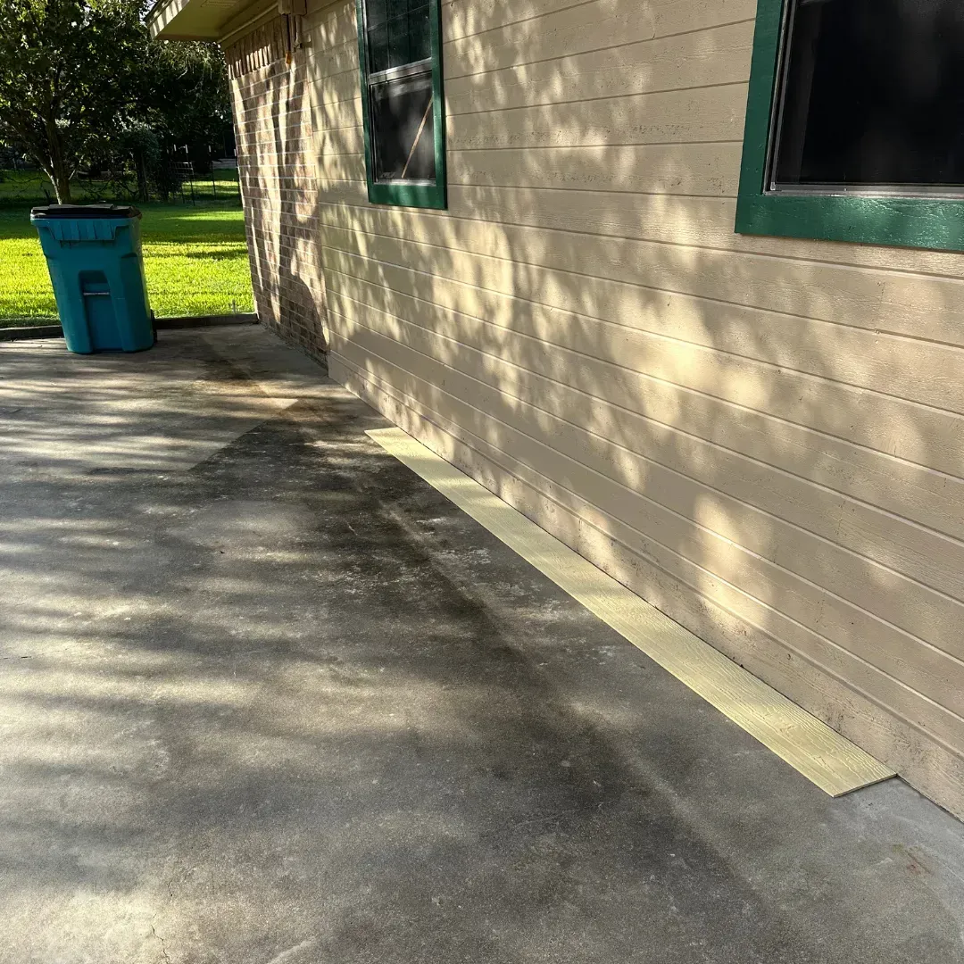 A house with a blue trash can in front of it
