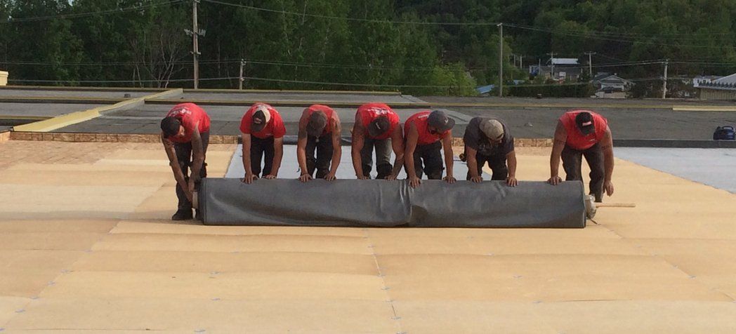 Un groupe d'ouvriers du bâtiment travaille sur un toit.