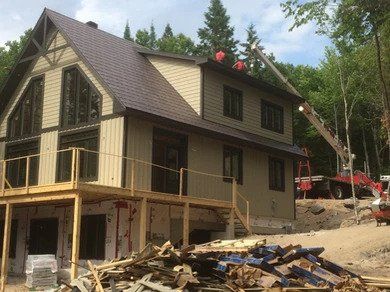 Une grande maison est en construction avec une grue sur le toit.