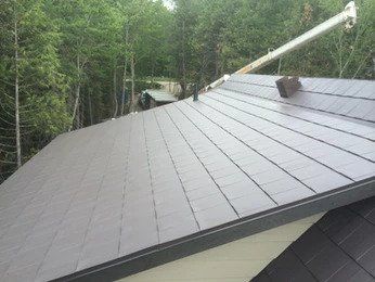 Un gros plan d'un toit avec une grue en arrière-plan.