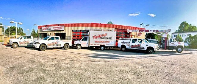 Une rangée de camions garés devant un bâtiment.