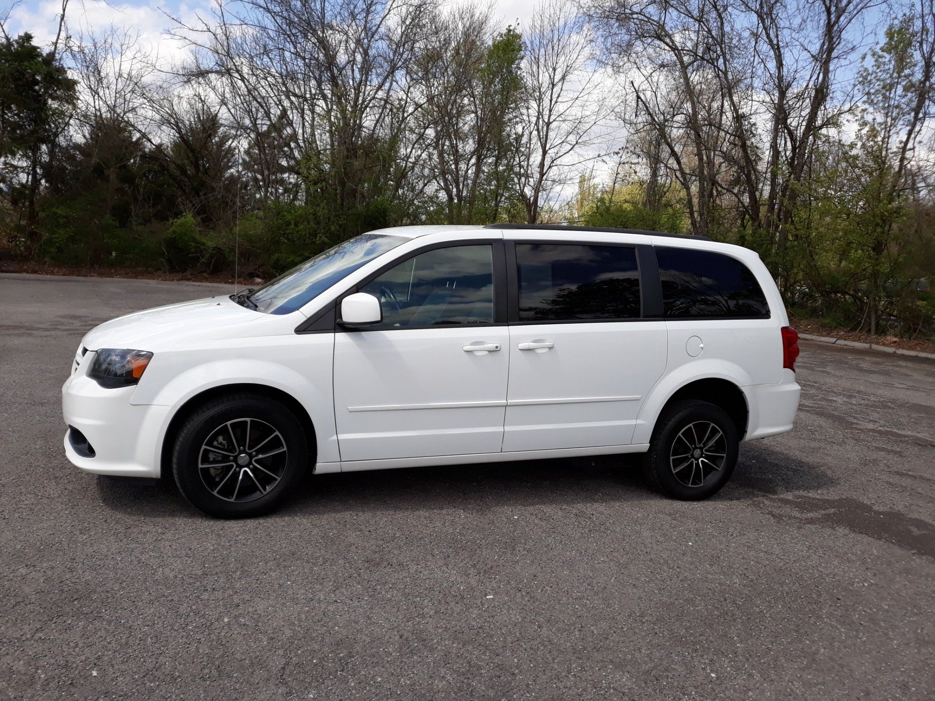 A white minivan is parked in a parking lot.
