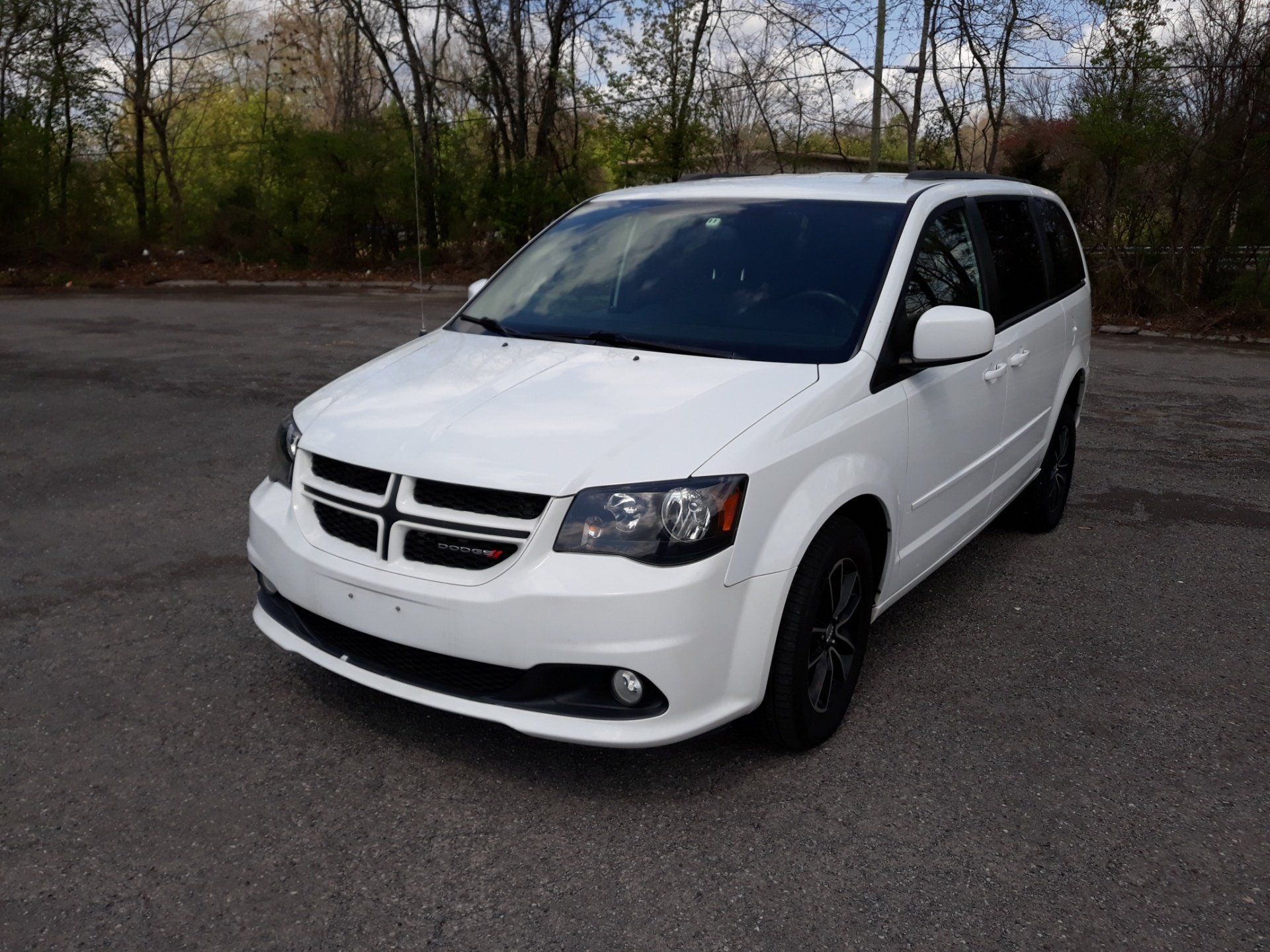 A white minivan is parked on the side of the road.
